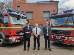 PFCC Peter McCall, CFO John Beard and Deputy PFCC Mike Johnson with Fire engines in behind them.